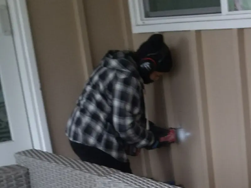Professional electrician installing an exterior outlet in St. John